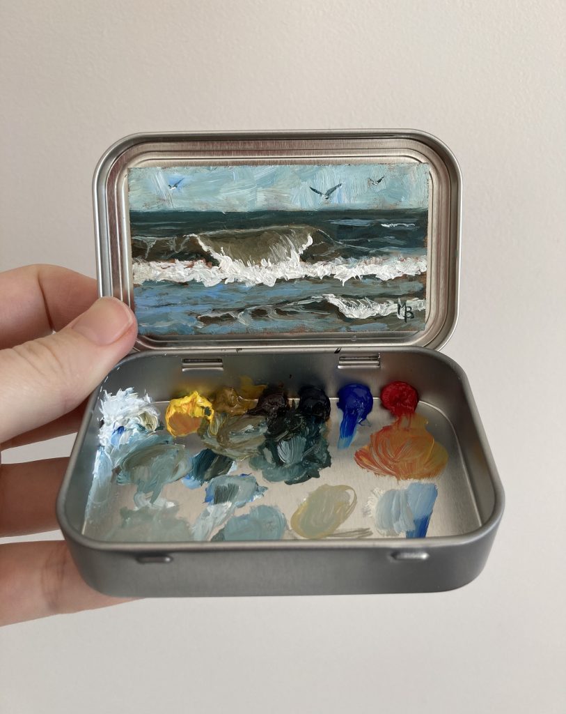 Blikvanger miniatuur schilderij in blikje met bijbehorende originele palet van zee met golf en meeuwen