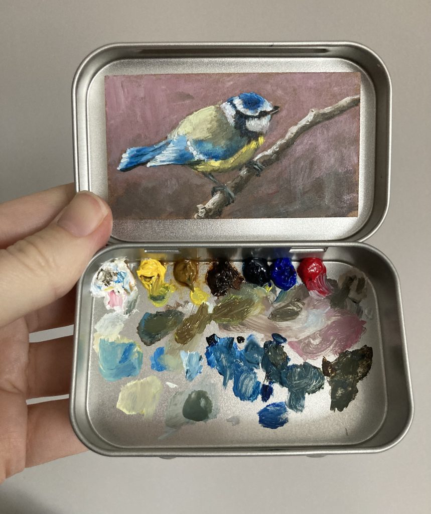 Blikvanger miniatuur schilderij in blikje met bijbehorende originele palet van pimpelmees op tak met oudroze kleur op achtergrond