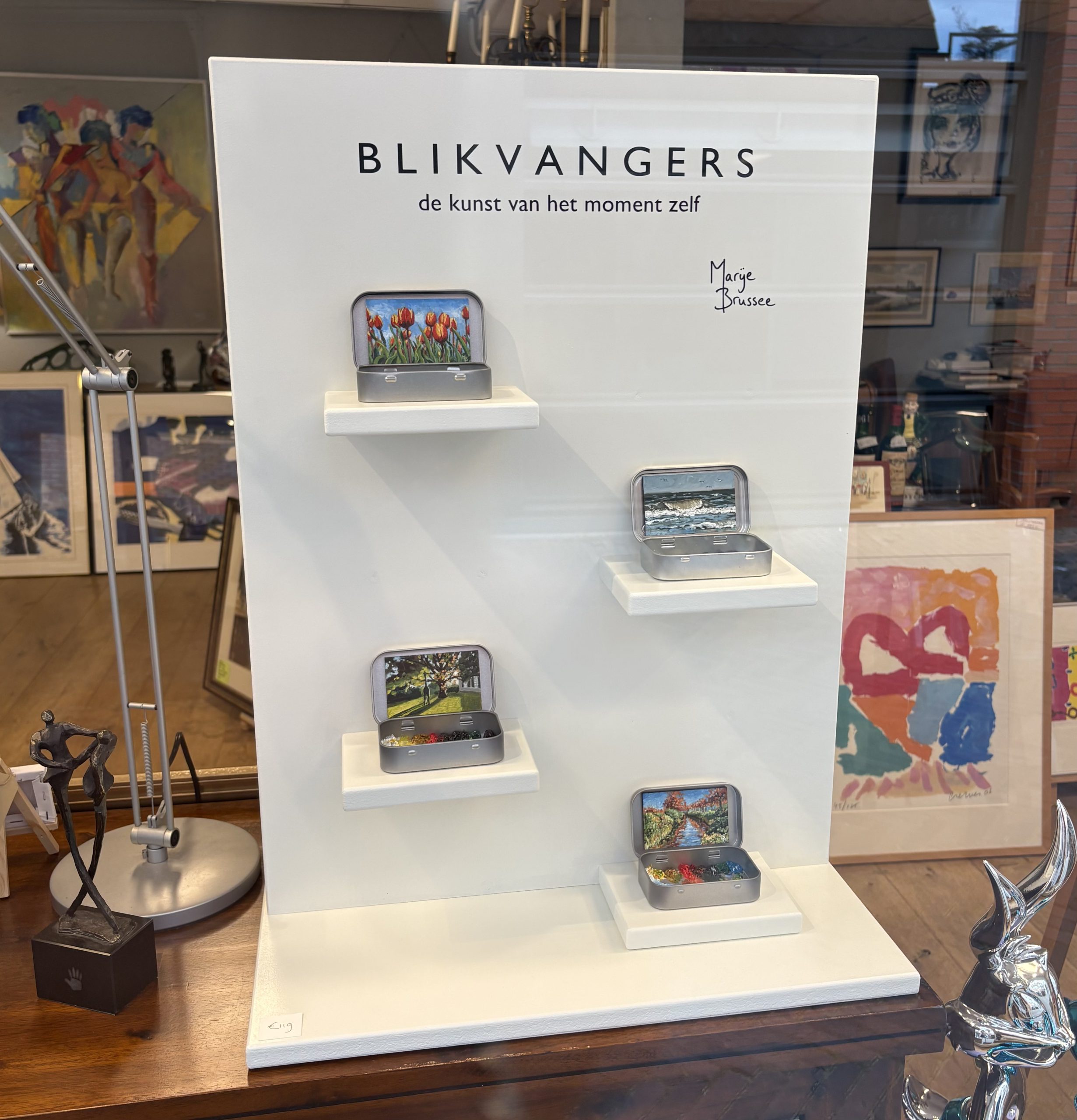 Display Blikvangers met miniatuur schilderijen en een blikje