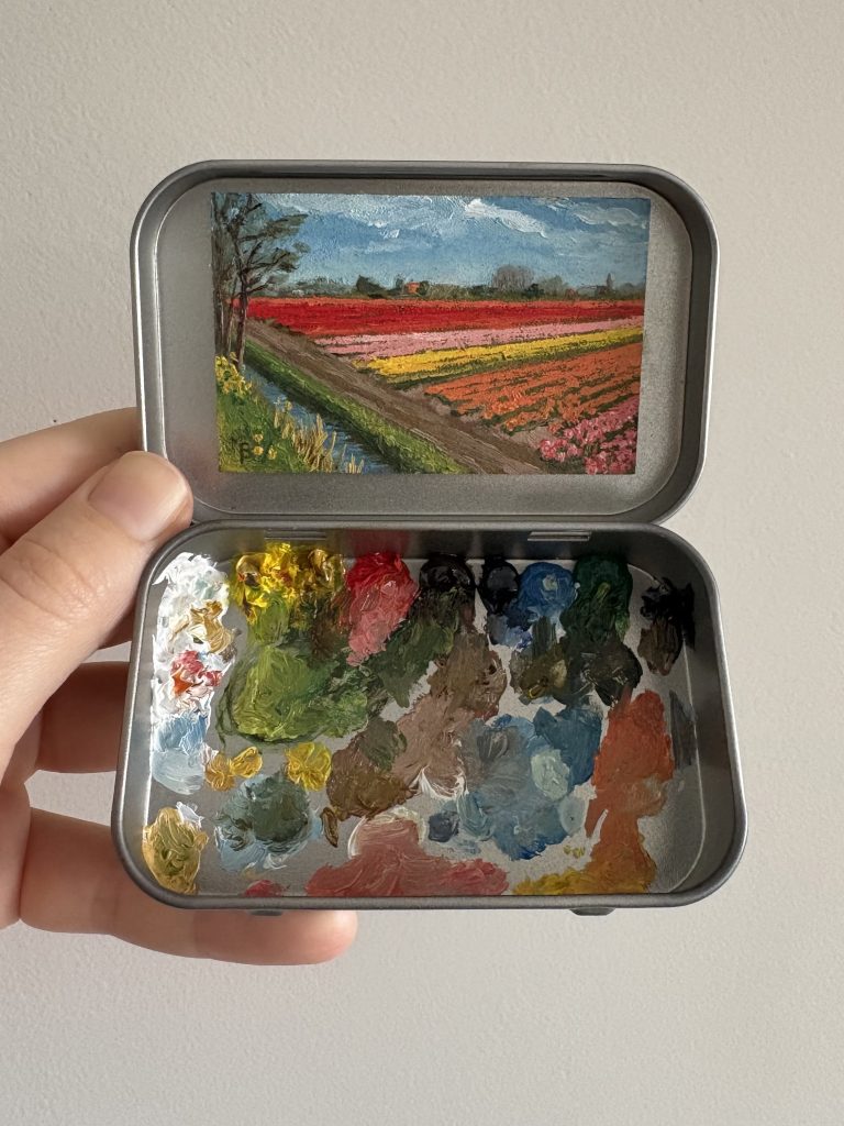 Blikvanger miniatuur schilderij in blikje met bijbehorende originele palet van bollenvelden bij Keukenhof